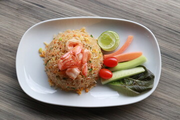 A delicious dish of shrimp fried rice served with fresh vegetables