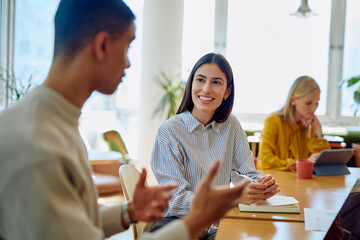 Diverse business colleagues engaged in a productive meeting, discussing ideas and planning work at an office table