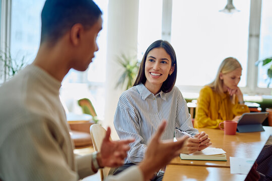 Diverse business colleagues engaged in a productive meeting, discussing ideas and planning work at an office table