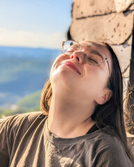 Woman enjoying sunshine with eyes closed outdoors