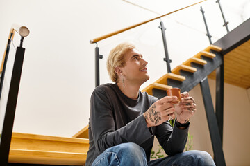 Young man enjoys a peaceful moment with a warm drink in a stylish apartment setting
