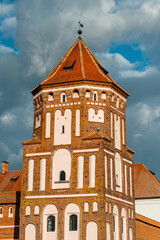 The castle building in the village of Mir in Belarus against the backdrop of a blue cloudy sky