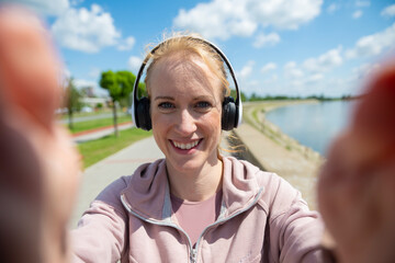 Happy woman recording selfie video using phone outdoors