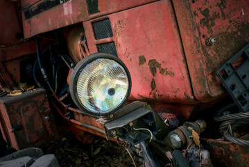 Close-up of weathered red tractor headlight