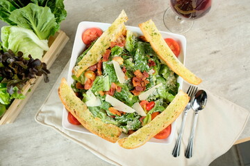 A visually appealing Caesar salad with appetizing ingredients, perfect for food enthusiasts. The image shows a fresh Caesar salad with croutons, bacon, and cheese