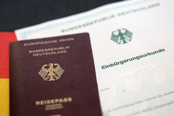 German passport on an official naturalization certificate. Symbolic for successful acquisition of German citizenship close up
