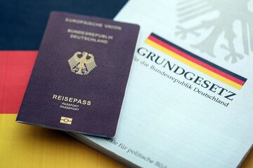 The constitution basic law book of Germany and passport lies on Germany flag background close up