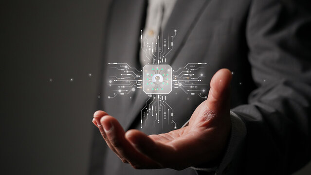 Businessman holding a holographic CPU with a user icon. Concept of cybersecurity, data protection, AI technology, and personal information privacy in the digital age.
