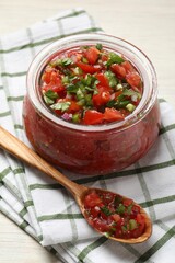 Tasty salsa in jar on white wooden table, closeup