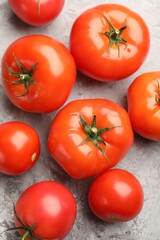 Fresh ripe tomatoes on grey textured table, flat lay