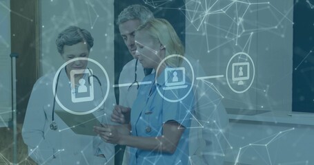 Three medical professionals consulting on patient data in corridor, with tablet and digital overlay