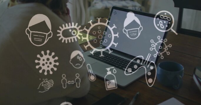 Leaning Asian woman gazing at laptop in home workspace with mug, smartphone and medical overlay - Powered by Adobe