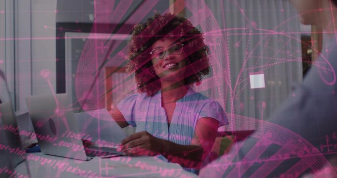 Gesturing data analyst woman explaining pink network overlay at office desk, with laptop graphics