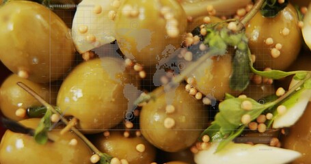 Glossy green olives tumbling closeup with mustard seeds and herbs under world map grid overlay