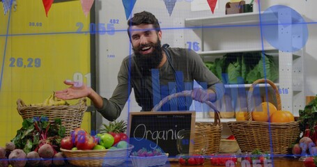 Gesturing apron-clad vendor holding wicker basket at market stall, with produce and Organic sign