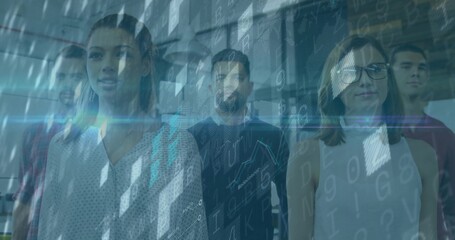 Standing group of software professionals examining digital code overlay in glass-partition office