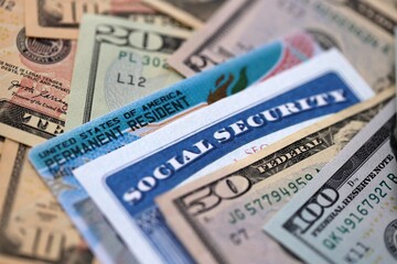 Social security number and permanent resident card with US dollar money bills close up