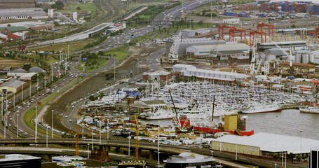 Fototapeta premium Showcasing industrial harbor and marina at coastal port, with shipping vessels and gantry cranes