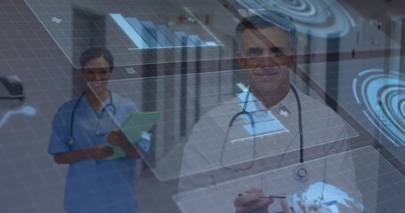 Tapping doctor using stylus on holographic charts in medical corridor, with nurse holding clipboard