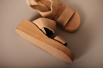 Stylish beige platform sandals with textured straps on a neutral background, minimalist fashion concept.