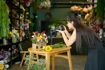 Young asian women owner floral store using digital camera take a photo bouquet sending to client. Women florist take a photo posing on social media or store online. Business and technology