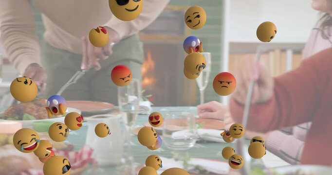 Family carving chicken serving salad at table with emojis floating for food marketing
