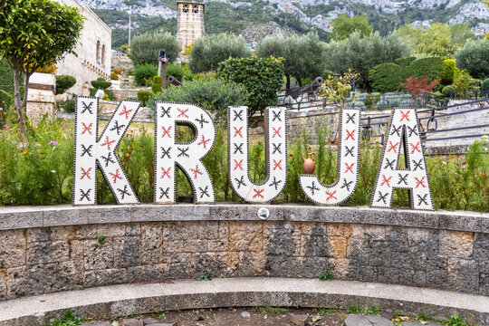 Large decorative KRUJA sign with traditional Albanian patterns at the entrance to the historic area of Kruja, Albania.