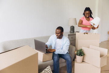 African couple moving to new home unpacking belongings