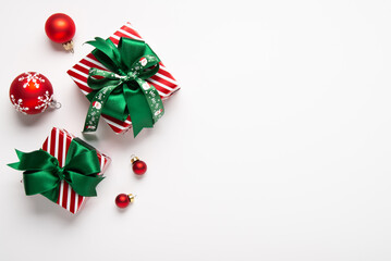 Merry Christmas and Happy Holidays greeting card, frame, banner. New Year. Red green Christmas decoration and gifts, presents on white background top view. Xmas holiday festive theme.