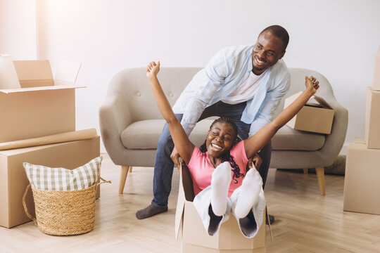 African couple having fun moving to new house - Powered by Adobe