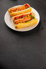 Hotdog fried onions, sausage, bun, sauce fast food tasty snack fresh delicious gourmet food background on the table rustic top view copy space