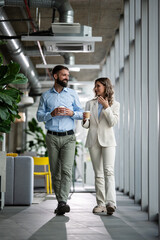 Fototapeta premium Business colleagues walking and talking during coffee break