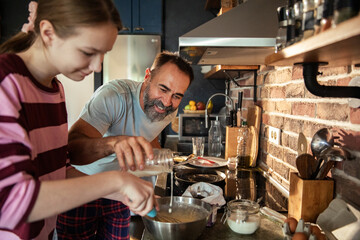 Father and daughter cooking together in kitchen