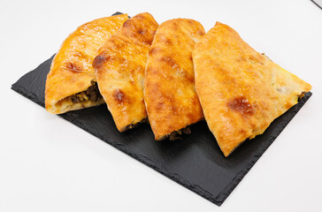 Four Golden Cheese and Meat Stuffed Flatbread Georgian Kubdari Slices on Slate Board