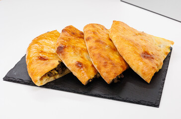 Four Golden Cheese and Meat Stuffed Flatbread Georgian Kubdari Slices on Slate Board