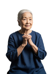 Elderly Asian woman in indigo linen tunic, white hair in bun, gentle clasped hands, wise serene expression on transparent studio background with copy space. Concept of quiet wisdom and dignity
