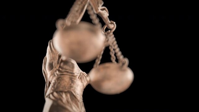 360 Degrees Rotating Seamless Looping Low Angle Lady Justice Statue Isolated on a Black Background.