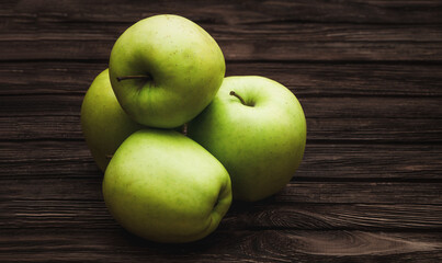 Green apples on dark brown wooden background. Summer fruits. Natural vitamins. Healthy food.