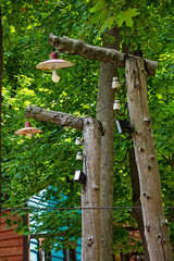 Vintage lanterns and lamps on an old wooden pole with wires. Rural street lighting