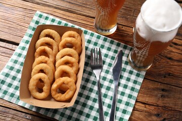 Fried squid rings and beer served on wooden table, above view
