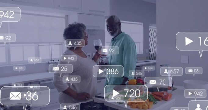Senior couple chopping and toasting wine initiating social icons appearing for marketing