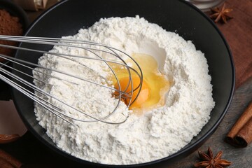 Ingredients for dough and whisk on wooden table, closeup