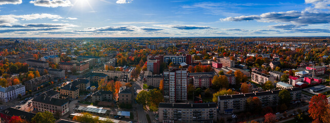 Aerial view of Jelgava, Latvia in late afternoon as sunbeams light mid rise blocks, churches, and...