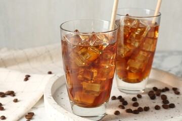 Tasty iced coffee and beans on table, closeup