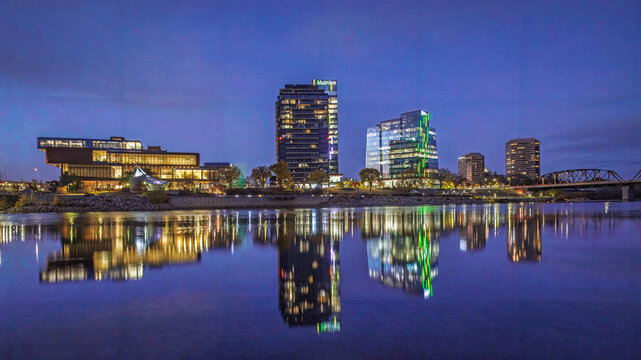 Wide angle nightscape, cityscape of Saskatoon River Landing area with beautiful water reflections.