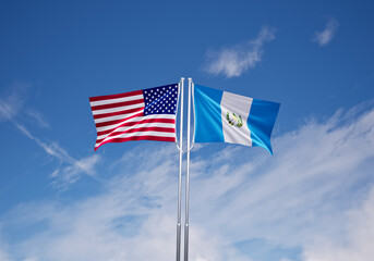 flags of  Guatemala and United States of America over blue sky background.