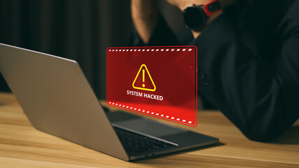 Cybersecurity breach alert on a laptop screen showing “system hacked” warning message, concept of data protection, cyber attack, hacking, computer security risk, and information safety crisis.