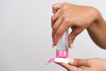 Woman applying liquid cleanser to cotton pad