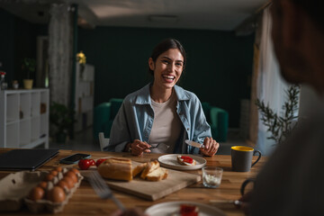 Couple enjoying healthy breakfast together talking at home