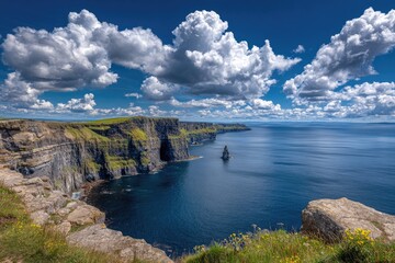 Dramatic cliffs meet the vast ocean under a cloudy, vibrant blue sky